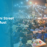 Crowded Karachi street food market with people enjoying outdoor dining.