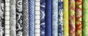 A collection of colorful printed fabric rolls arranged vertically